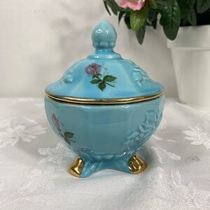 Blue porcelain lidded jar with a raised design and roses